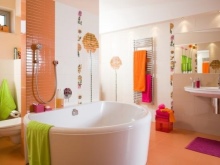 Salle de bains orange et blanche avec des accessoires verts et roses